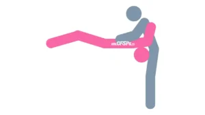 This stick figure image depicts a man and woman engaging in oral sex in the Throat Swab blowjob sex position. The woman is lying on her back with her head off the edge of the bed and upside down. The man is standing at the edge of the bed with his pelvis near her face and caressing her breasts or stimulating her clitoris with his hands.